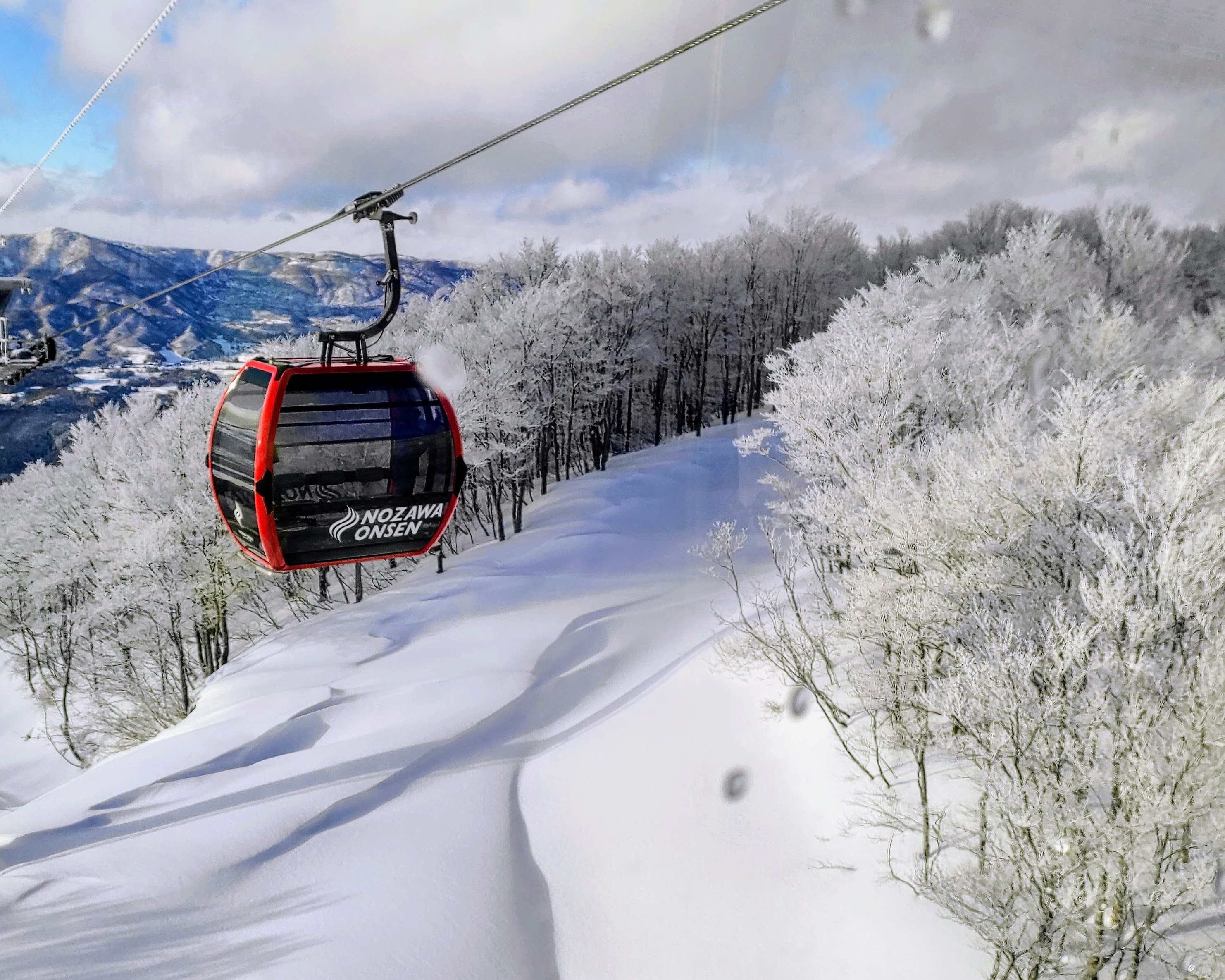 Nozawa Onsen gondala above snowy piste