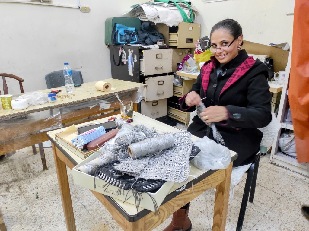 A woman makes up-cycled handbags in a workshop in Mansheyat Nasir 
